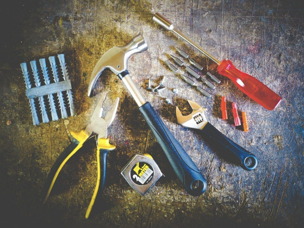 A photo of a hammer, screwdriver, wrench, and other tools. How To Efficiently Dismantle And Move Your Bed Frame.