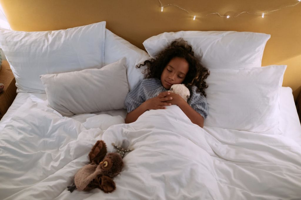 A little girl hugging a plush toy while sleeping.