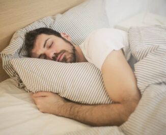 Ideal Bedding Materials For Humid Or Dry Climates. A man sleeping in a bed.